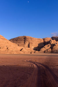 Scenic view of desert against clear blue sky