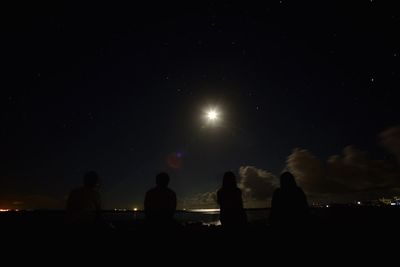 Silhouette people against sky at night