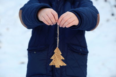 Close-up of boy holding wooden christmas tree