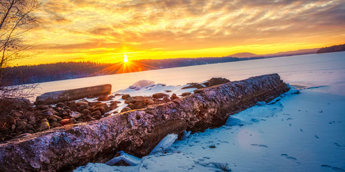 Scenic view of snowcapped mountains against sky during sunset