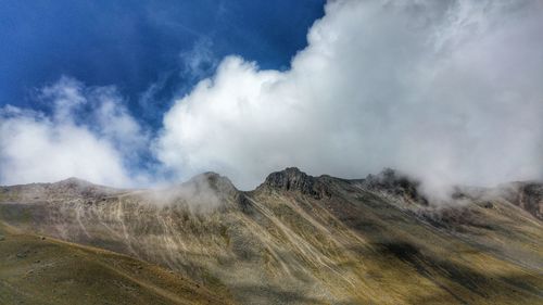 Scenic view of mountains against cloudy sky