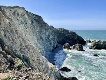 Rock formations by sea against sky