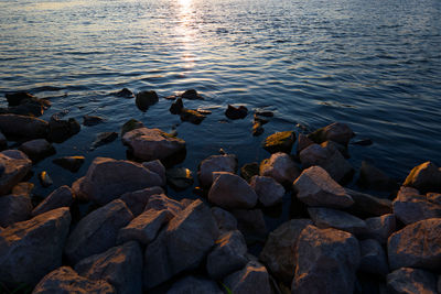 Rocks in sea at sunset