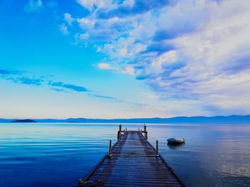 Wooden pier over sea against sky