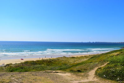 Scenic view of beach against clear blue sky