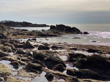 Rocks on beach against sky