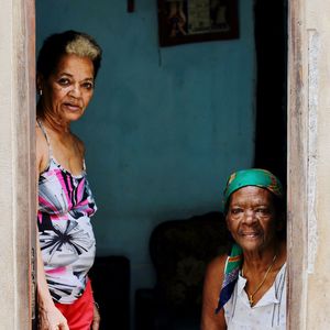 Portrait of smiling woman standing against wall