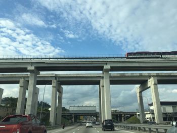 Cars on bridge against sky