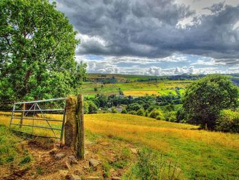 Scenic view of field against cloudy sky