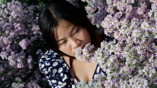 Close-up of woman against purple flowering plants