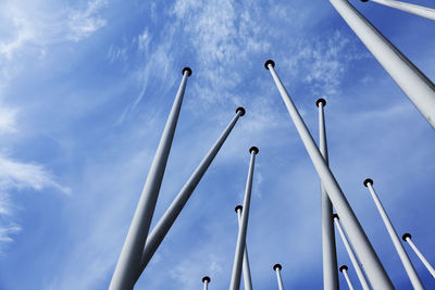 Lots of empty flagpoles against a blue sky
