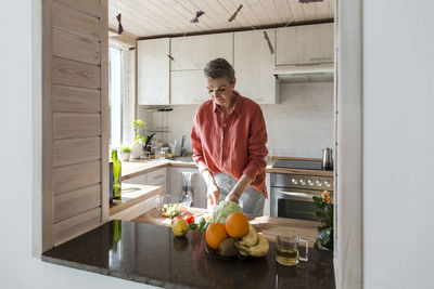 Woman preparing salad in kitchen at home