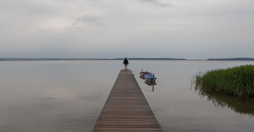 Pier on lake against sky