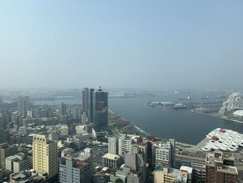 High angle view of buildings by sea against clear sky