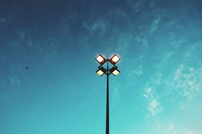 Low angle view of illuminated street light against blue sky