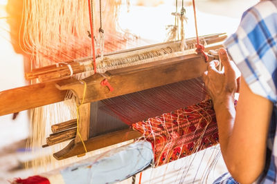 Rear view of woman working on loom