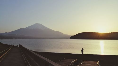 Scenic view of lake and mountains against clear sky