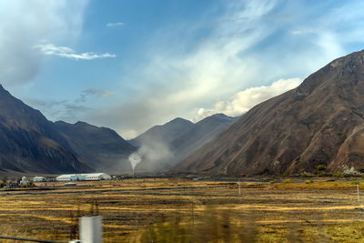 Scenic view of lake by mountains against sky