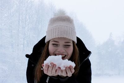 Portrait of a young woman holding snow