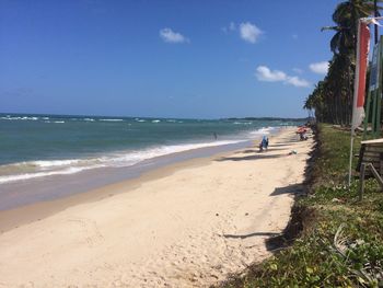 Scenic view of beach against sky on sunny day