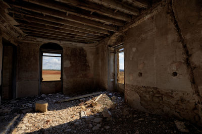 Old room with debris, broken windows and fissured wall