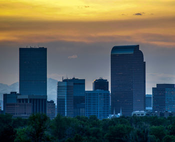 Buildings in city against cloudy sky