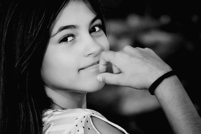 Close-up portrait of young woman with hand on chin