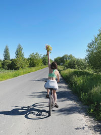 Rear view of woman walking on road