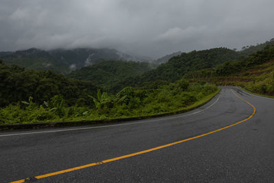 Countryside road passing through the lush green tropical rain forest mountain landscape