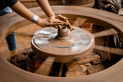 A slow shutter shot of a potter hand making a pot from a pottery wheel at hubli, karnataka, india.