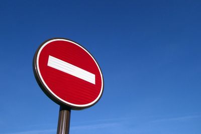 Low angle view of do not enter sign against clear blue sky