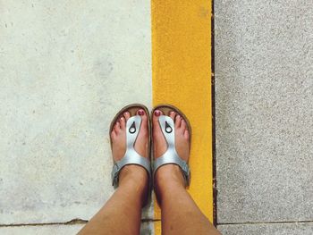 Low section of woman standing on road