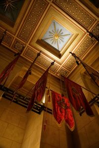 Low angle view of illuminated chandelier hanging on ceiling in building