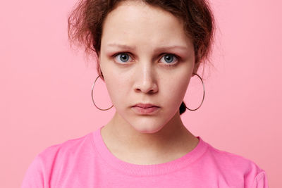 Portrait of young woman against yellow background