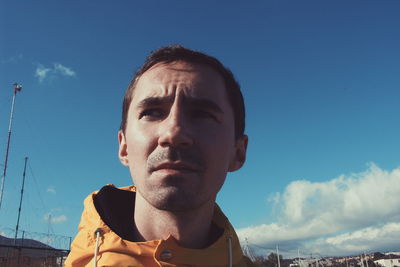 Portrait of young man against blue sky