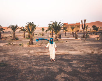 Woman with palm trees against clear sky