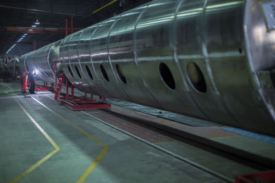 Man welding large steel tank in factory
