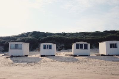 Beach hut on shore against sky