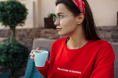 Portrait of young woman drinking coffee