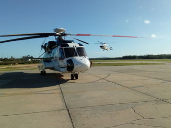 Helicopter over runway against sky