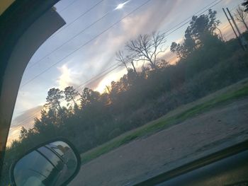 Road seen through car window during sunset