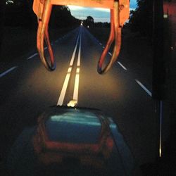 Low section of person on illuminated road at night