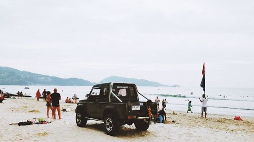 People at beach against sky