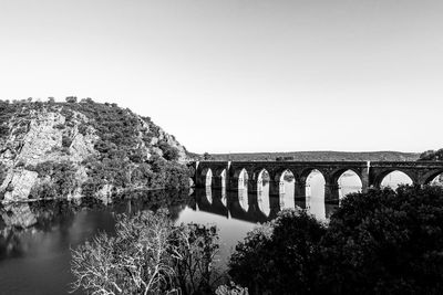 Arch bridge over river against sky