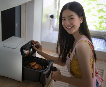 Portrait of a smiling young woman at home