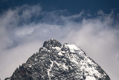 Low angle view of snowcapped mountain against sky