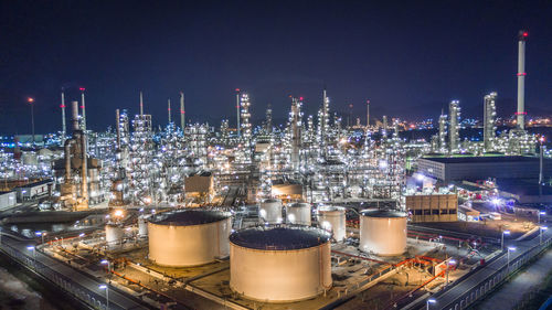 High angle view of illuminated factory in city at night