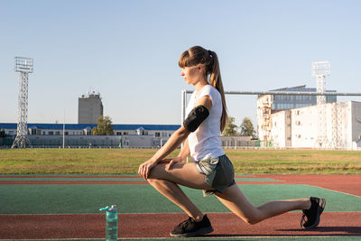 Fitness and sports. teenager girl doing stretching at the stadium