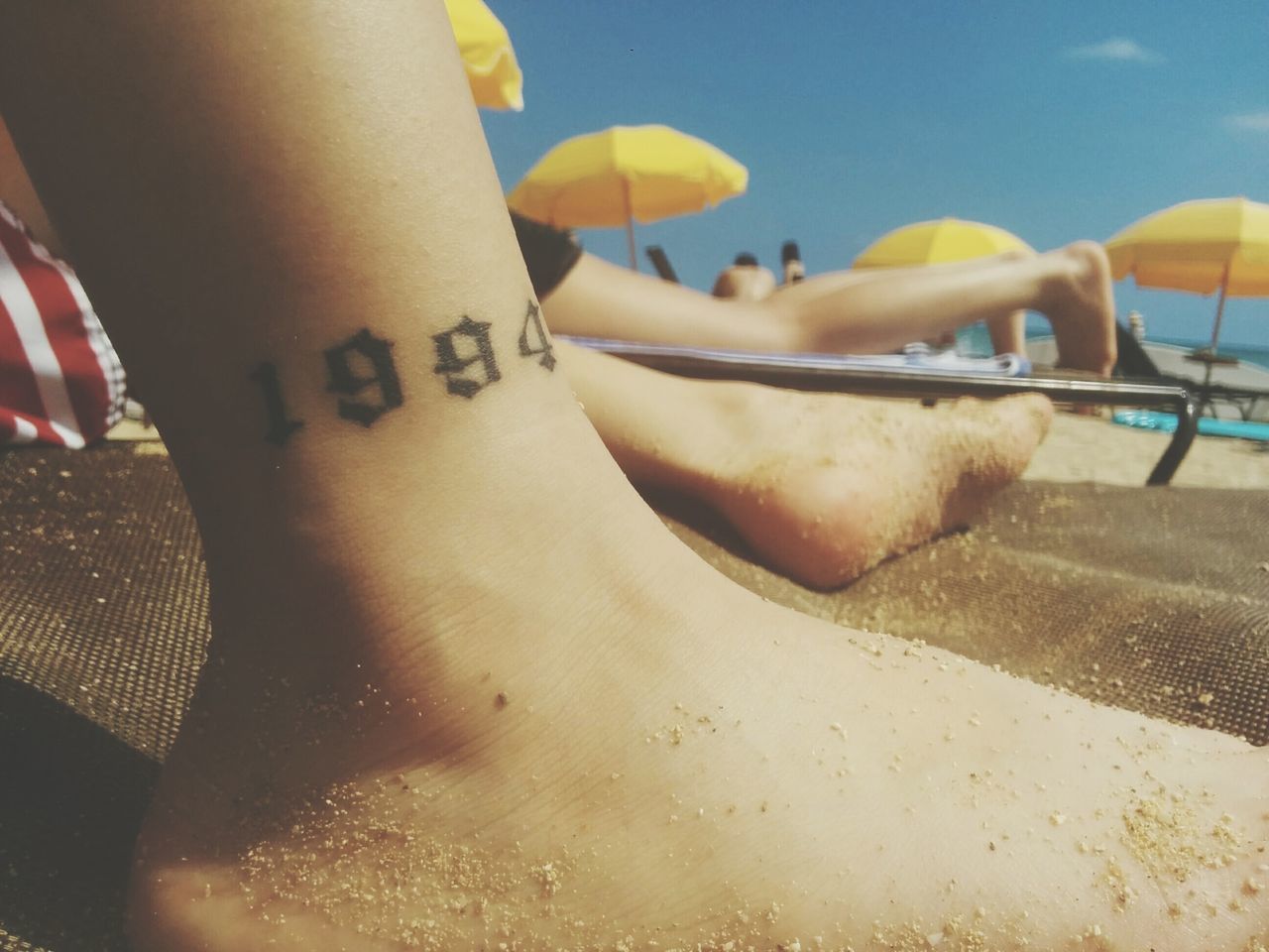 cropped, part of, lifestyles, leisure activity, person, close-up, sunlight, sand, beach, animal themes, unrecognizable person, text, men, outdoors, day, low section, relaxation