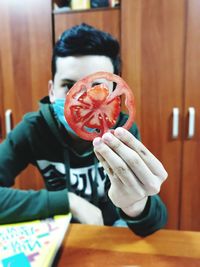 Portrait of man holding ice cream at home